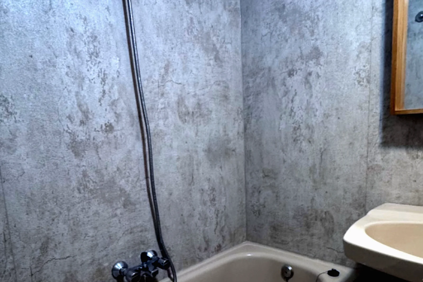 Baño con bañera y paredes en microcemento aplicado sobre el alicatado