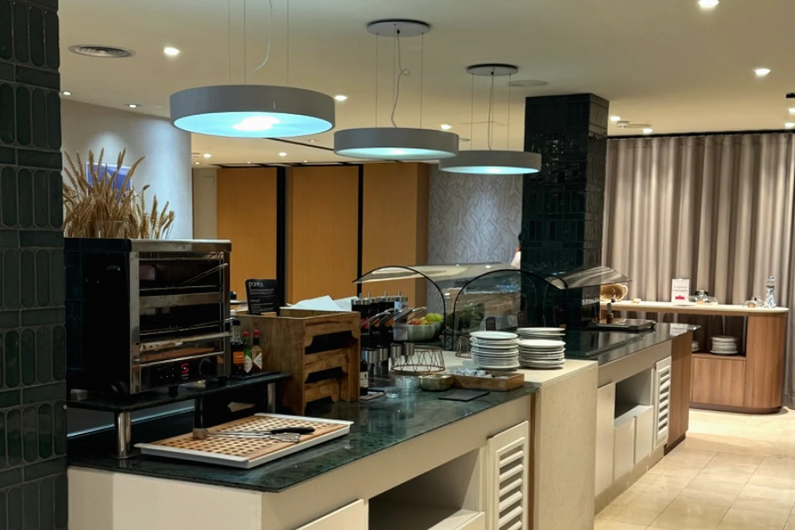 Sala de desayunos de hotel con columnas de mármol verde y buffet revestido